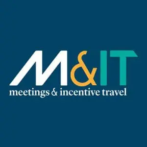 Logo with a blue background featuring the letters “M&IT” in large white, orange, and green font. Below, it reads “meetings & incentive travel” in smaller white text. Logo with a blue background featuring the letters "M&IT" in large white, orange, and green font. Below, it reads "meetings & incentive travel" in smaller white text.