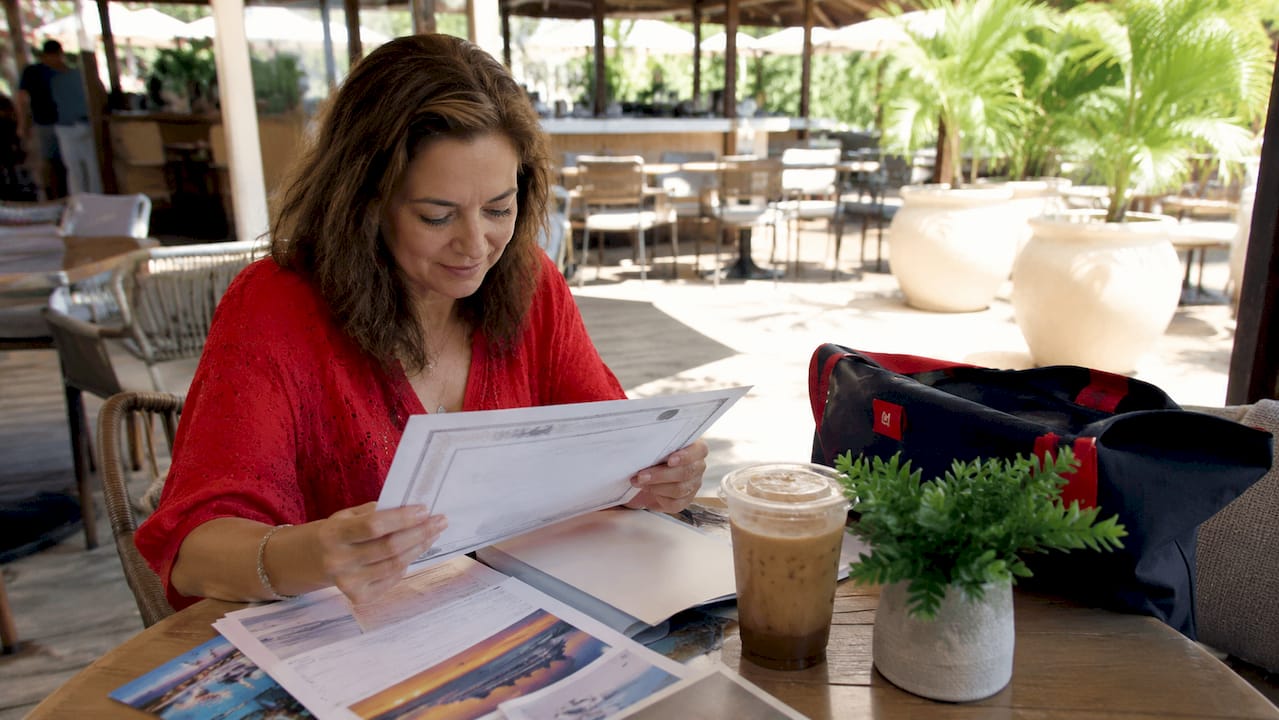 woman reviewing travel auction certificate at desk
