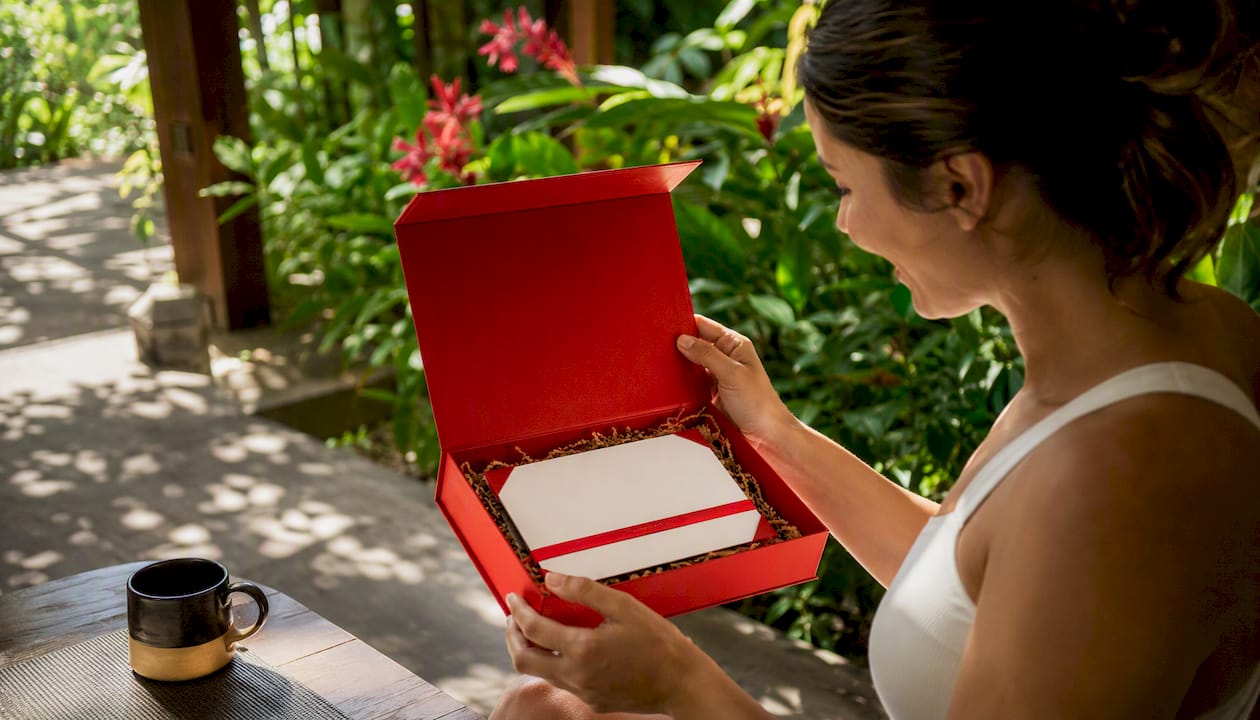 hands unwrapping travel gift by resort pool