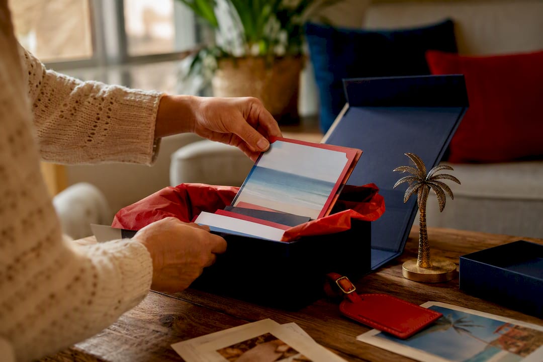 how to buy gift cards in bulk for corporate programs in 2026 3 hands arranging travel certificate gift box contents
