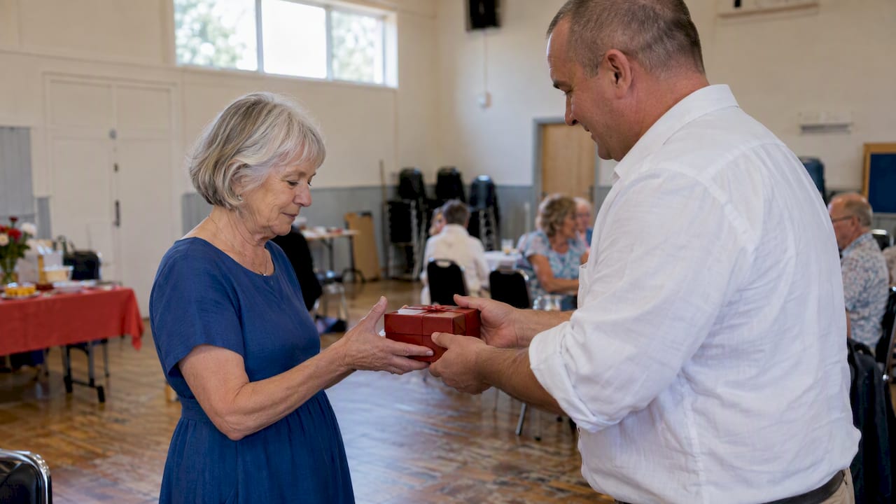 Retirement guest receiving a red gift box